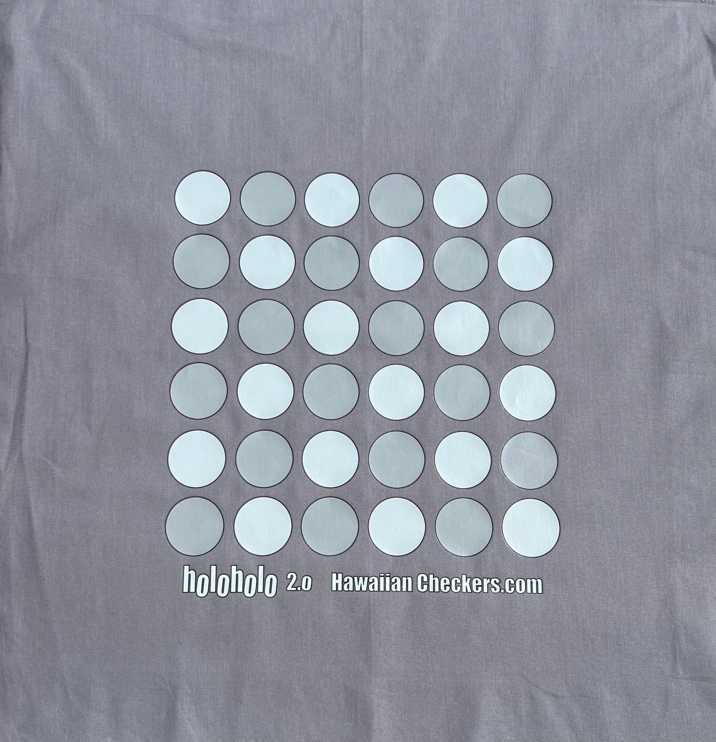Gray Holoholo with a pattern of white and light gray circles and text on a plain background