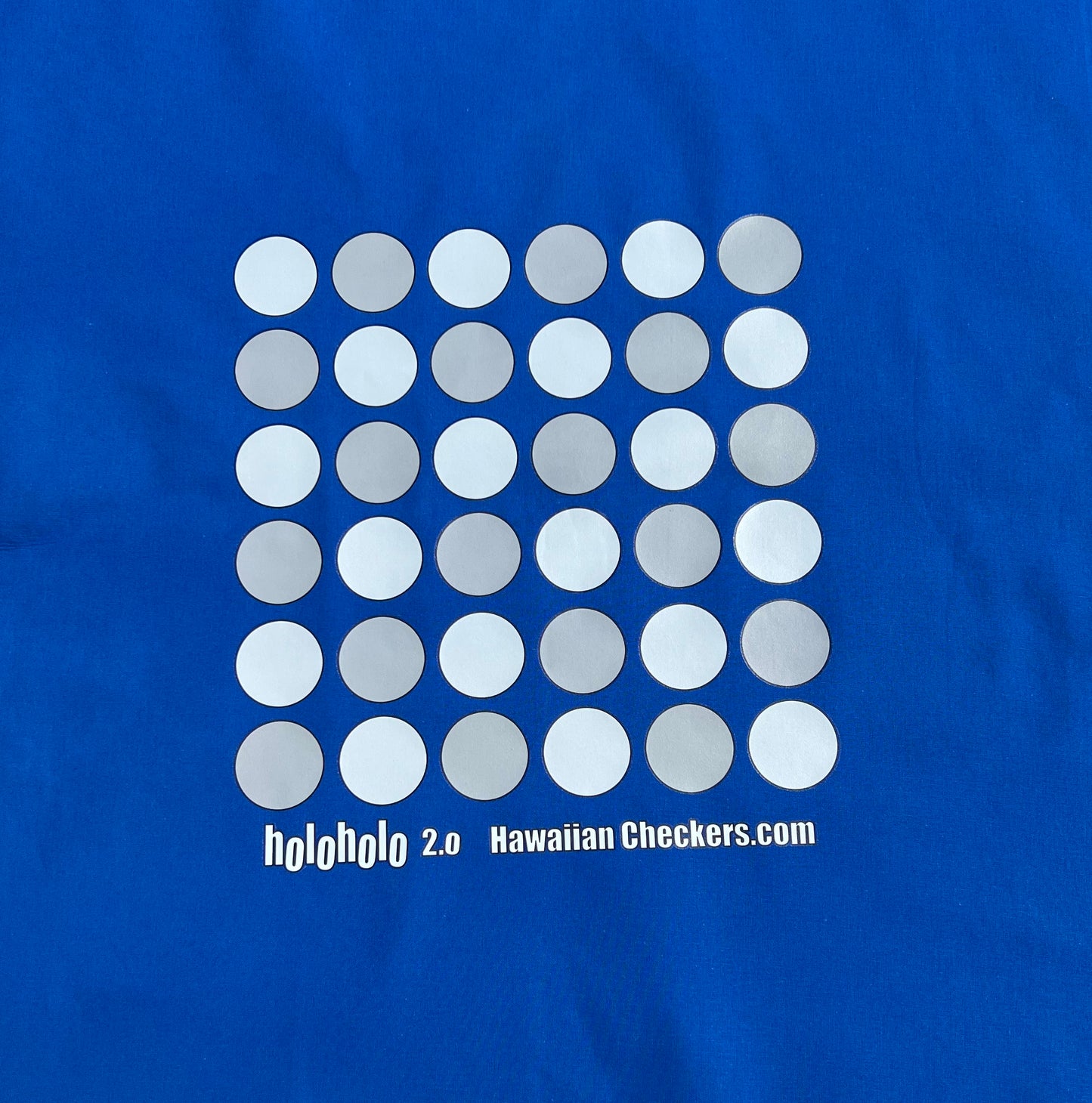 A festive royal colored cotton fabric board displaying Holoholo 2.0 Papamū ready to play Konane.
