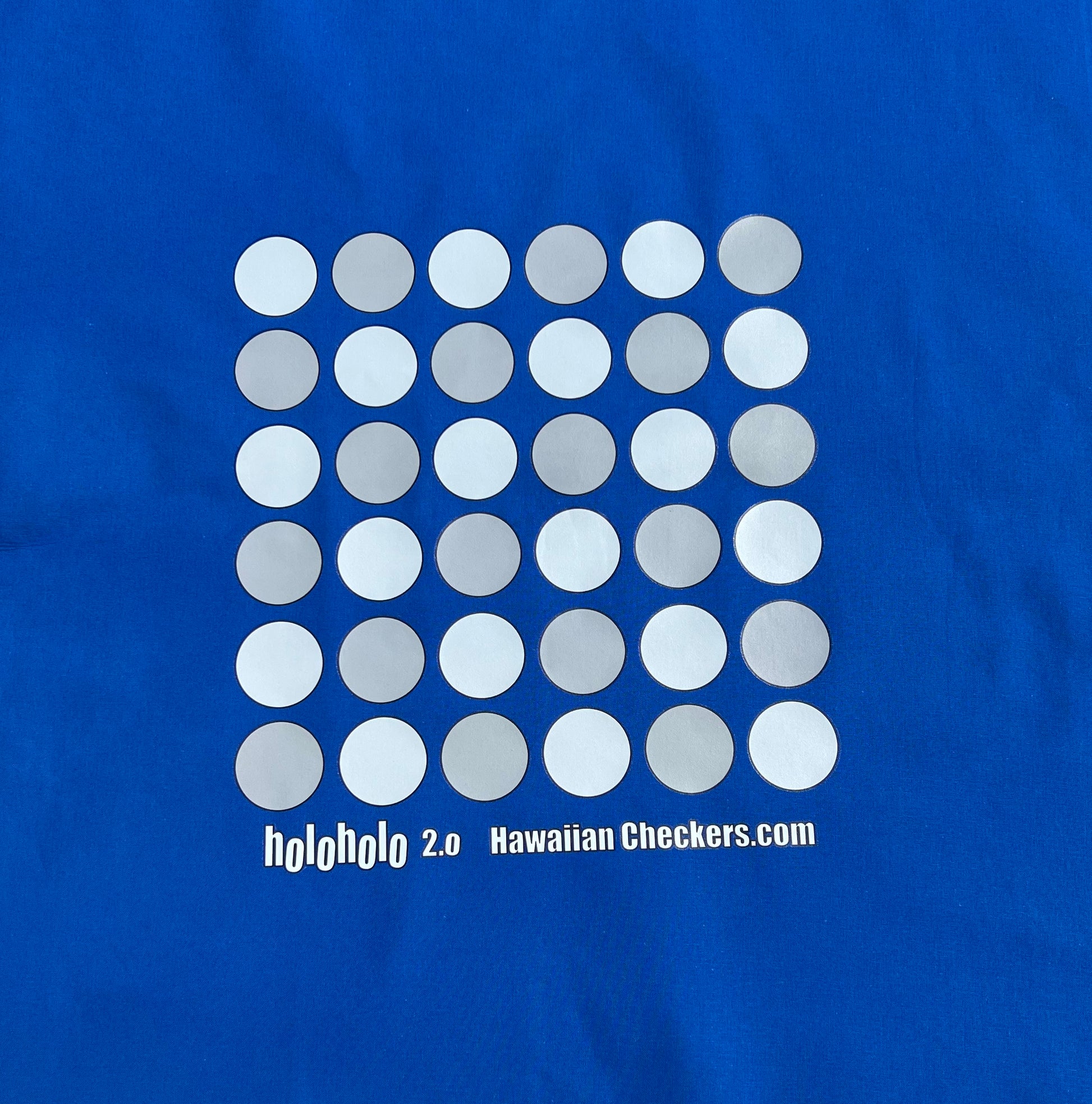 A festive royal colored cotton fabric board displaying Holoholo 2.0 Papamū ready to play Konane.
